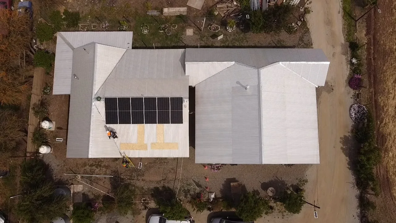 Vista cenital de una vivienda rural con su arreglo fotovoltaico terminado sobre el techo