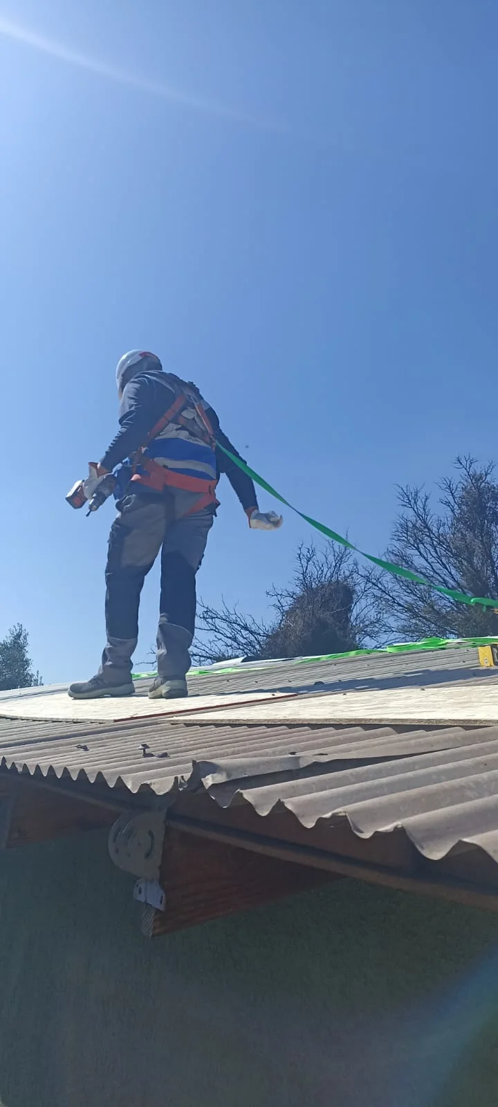 Instalador trabajando sobre la cubierta con arnés de seguridad y línea de vida