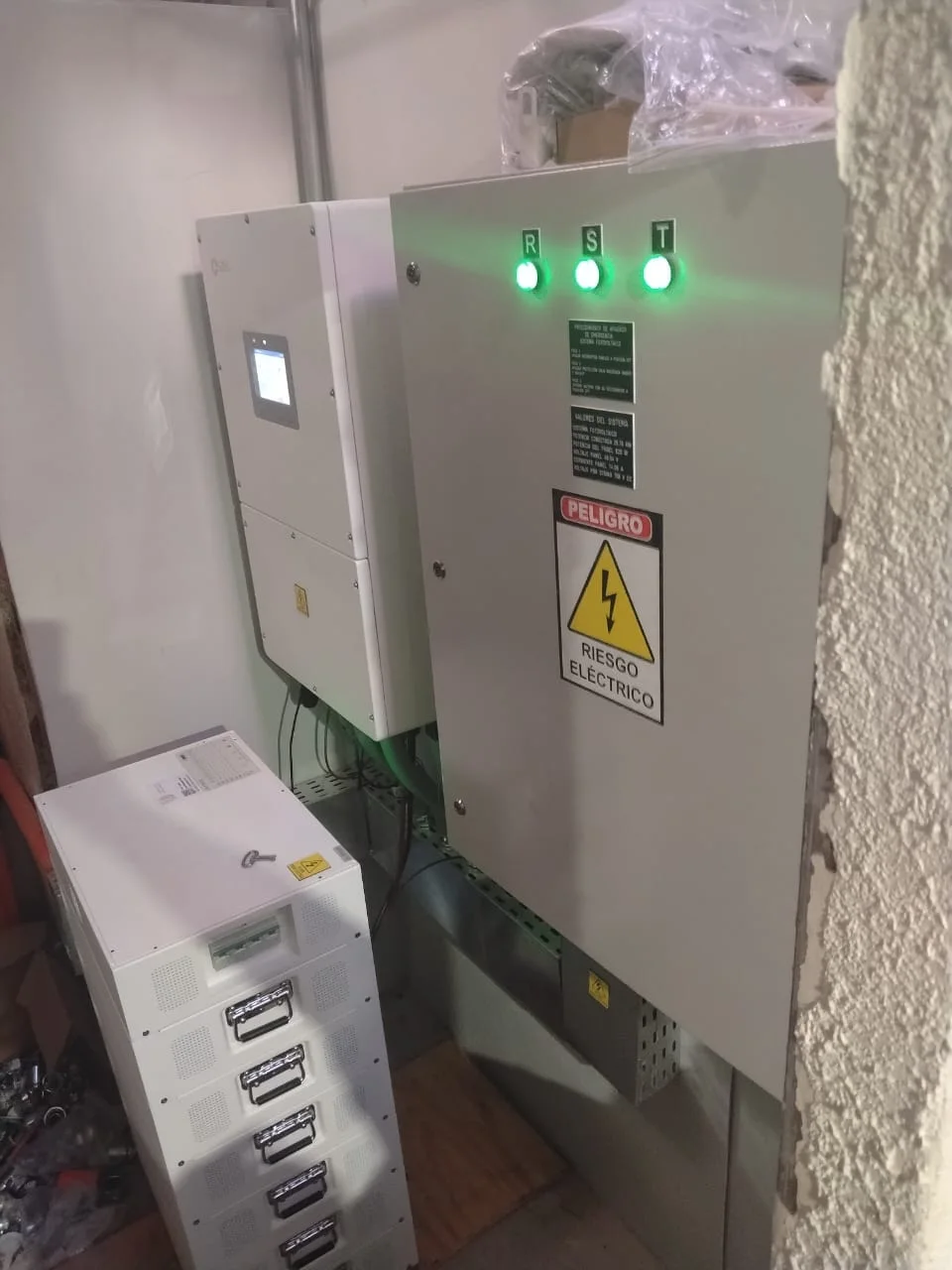 Inversor híbrido, banco de baterías en rack y tablero fotovoltaico con luces piloto R-S-T